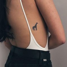 the back of a woman with a giraffe tattoo on her left side ribcage