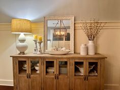 a dining room table with plates and bowls on it, next to a large mirror