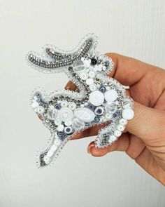 a hand holding a brooch with buttons on it