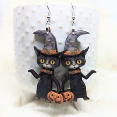 Black Cat Witch Hat Earrings  ~ Measures Approx 2 inches long ~ Stainless steel ear wires  ~ Comes packaged on backing    ~ Made of lightweight wood ~ Laser cut and printed with a matte glaze.   Processing time is up to two weeks, may be sooner if item is currently in stock. Thanks! follow us @iamsonotcoolvintage on instagram  save 10% :) Halloween Cat Ears Earrings For Pierced Ears, Halloween Cat Ears Earrings, Halloween Cat Design Earrings With Cat Ears, Black Cat Ears Earrings For Halloween, Black Cat Earrings, Laser Cut Wood Earrings, Chat Halloween, Witch Earrings, Pumpkin Earrings