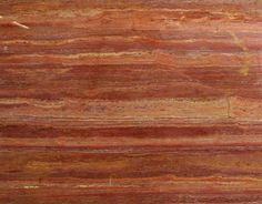 a close up view of a red marble counter top with yellow and brown streaks on it