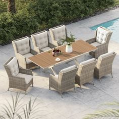 an outdoor table and chairs next to a pool