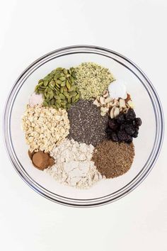 a bowl filled with different types of seeds and nuts on top of a white table