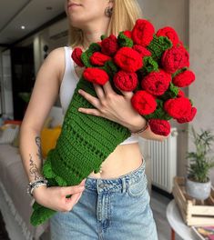 a woman holding a bouquet of red flowers