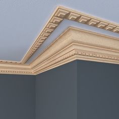 the corner of an empty room with molding on the ceiling