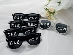 six pairs of personalized sunglasses with the names of each pair and date on them