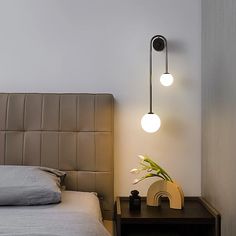 a bed room with a neatly made bed and two lights on the wall above it