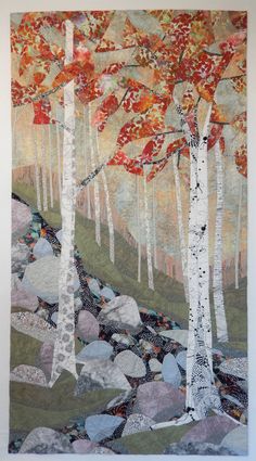 a quilted wall hanging with trees and rocks