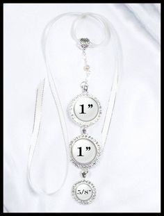 a white necklace with the number one on it and two charms hanging from it's side