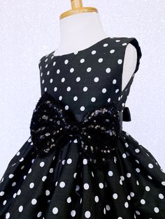 Hand stitched together with the upmost care, this dress is perfect for any occasion: birthdays, pageants, photoshoots, and holiday parties! The comfortably soft polka dot dress is made out of cotton material; The bodice is sleeveless with a zipper in the back. The dress comes with a detachable ribbon sash and mini sequin small bow to add sparkle. Knee length skirt made out of cotton polka dot fabric. Under the skirt is one layer of lining with crinoline attached to add extra puffiness. *Mannequi Fitted Princess Dress With Bow For Dress-up, Black Princess Dress For Dress-up, Black Sleeveless Princess Dress For Dress-up, Black Fitted Sleeveless Princess Dress, Black Dress With Bow For Party Season, Fitted Princess Dress For Holiday Costume Party, Fitted Black Princess Dress For Dress-up, Fitted Princess Dress With Bow For Pageant, Sleeveless Black Dress For Birthday