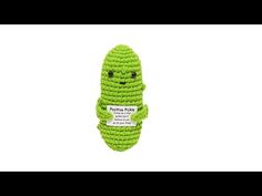 a green crocheted toy with a face on it