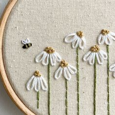 some white flowers and a bee are in the hoop