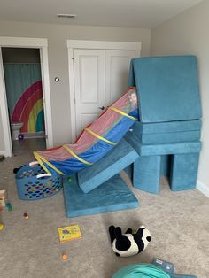 a child's play room with toys on the floor and inflatable slides