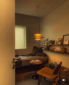 a bedroom with a bed, desk and shelves on the wall next to each other