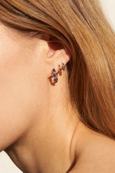 a close up of a person's ear with two small earrings on top of it