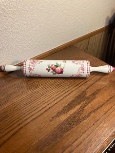 a white and red toothbrush sitting on top of a wooden table next to a wall