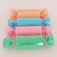 six rolls of candy wrapped in plastic wrappers with bows on them, sitting next to each other