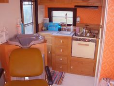 a kitchen with an oven, sink and chair