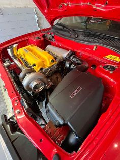 the engine compartment of a red car with its hood open