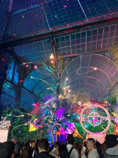 a large group of people standing in front of a stage with lights and decorations on it