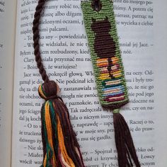 an open book with a tasseled bookmark on top of it, sitting on a table