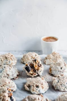 cookies are arranged on a baking sheet with a cup of coffee in the back ground