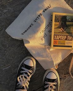 there is a book and pair of sneakers on the ground next to a bag with an advertisement