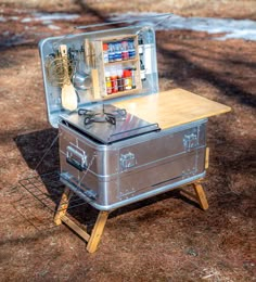 an old suitcase is turned into a picnic table with utensils and other items in it