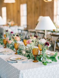 the table is set with flowers and plates