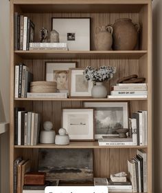 a book shelf filled with books and vases