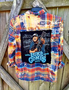 This is a one of a kind LUKE COMBS plaid flannel shirt.  This size LARGE flannel shirt has two pockets on the front, buttons up and is long sleeve. On the back of the shirt is a Luke Combs concert tee that has been sewn into the back of the shirt. The trim around the tee is frayed. This shirt has been bleached which gives it an overall distressed vintage style look.  All my shirts are ONE OF A KIND. They are all upcycled by being previously owned so there will be signs of wear and tear. This is Distressed Button-up Shirt For Fall, Fall Pre-washed Button-up Shirt, Mens Flannel, Concert Tees, Plaid Flannel Shirt, Oversized Jacket, Plaid Flannel, Flannel Shirt, Bleach