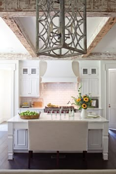 a kitchen with white cabinets and an island in front of the stove top is surrounded by sunflowers