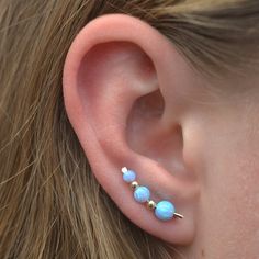 "What is not to love about this gorgeous Opal Graduated Gem Ear Climber! The colors are much more stunning than this photograph can show. It fits gracefully up the natural shape of your ear with shimmer and pizzazz! This earring only requires one standard ear piercing. It is shaped like a bobby pin, and the wire on the back of the ear holds the ear pin in place, comfortably and securely. We use synthetic opals laboratory made, and slide from 3mm to 5mm gems onto a 19 gauge sterling or gold fille Three Ear Piercings, Ear Pins Earrings, Gold Ear Climbers, Tiny Gold Studs, Turquoise Earring, Ear Pin, Silver Ear Climbers, Ear Crawler, Ear Crawlers