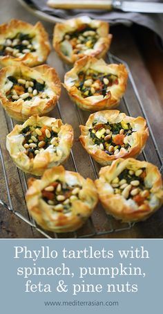 mini pizzas with spinach, pumpkin, and pine nuts on a cooling rack