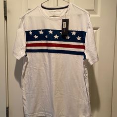 A Must Have! Size Medium. Great Shirt! White Cotton Tommy Hilfiger T-shirt, Cotton Americana Shirt With Crew Neck, Short Sleeve Cotton Americana Shirt, Casual Cotton Shirt For 4th Of July, White Americana Crew Neck Top, Casual White Shirt With American Flag Print, White Shirt With Flag Print For Spring, White Casual Shirt With Flag Print, Casual White Shirt With Flag Print