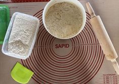 there is a bowl with some flour in it next to a measuring cup and spatula