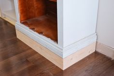 the corner of a room that has been stripped off and is being remodeled with wood flooring