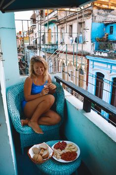 a woman sitting on a chair with food in front of her