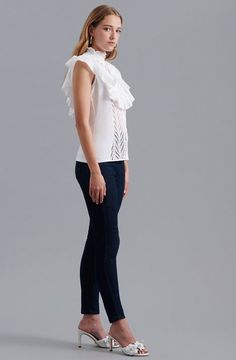 The CENITZ is an eyelet top featuring a mock ruffle neck and a ruffle bib detail on the front yoke, along with a center front button placket for closure. The light eyelet cotton fabric is durable but soft, making it ideal for wearing in warmer temperatures all year round. White embroidered shirt with ruffle cap sleeves Center front button placket for closure This top is made of embroidered open eyelet cotton Body: 100% Cotton; Side Panels: 92% Cotton, 8% Elastane Lightweight and airy, this fabri Elegant Cotton Eyelet Tops, Chic Cotton Eyelet Blouse, Chic Cotton Blouse With Eyelet Details, Cotton Top With Broderie Anglaise And Ruffled Collar, Feminine Tops With Broderie Anglaise And Ruffled Collar, Chic Blouse With Broderie Anglaise And Ruffled Collar, Workwear Tops With Lace Trim And Ruffled Collar, Chic Tops With Broderie Anglaise And Ruffled Collar, Chic Fitted Eyelet Blouse