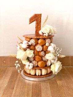 there is a cake made to look like a number one with flowers and nuts on it