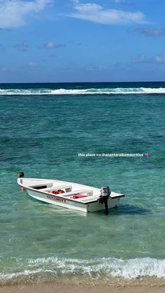 a small white boat sitting on top of the ocean