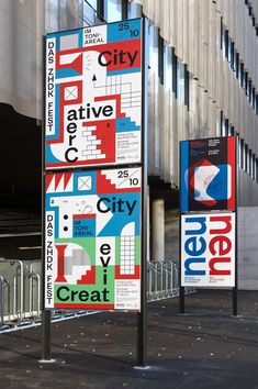 two street signs on poles in front of a building