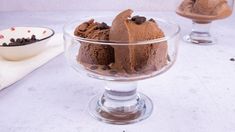 two dessert dishes with chocolate ice cream and cookies in them on a white counter top