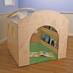 a child's book shelf with books in it on the floor next to a wall