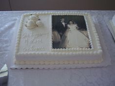 a wedding cake with an image of a bride and groom on the side, sitting on a table