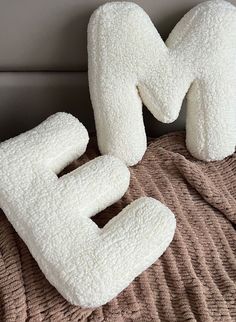 two pillows shaped like the letter e on a bed