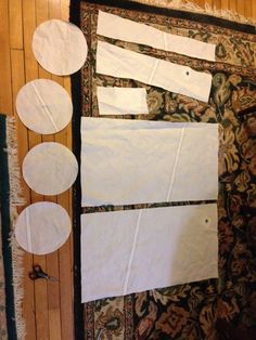 several pieces of white paper taped to the wall with circles on it and some holes in between them