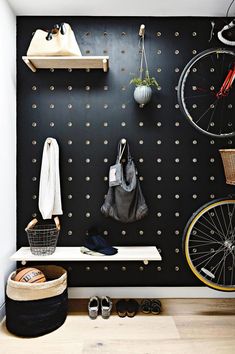 a bicycle is hanging on the wall next to a shelf with shoes and other items