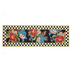 a black and white checkered table runner with flowers on the border, in front of a