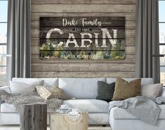 a living room with a white couch and wooden wall behind it that says, date family cabin